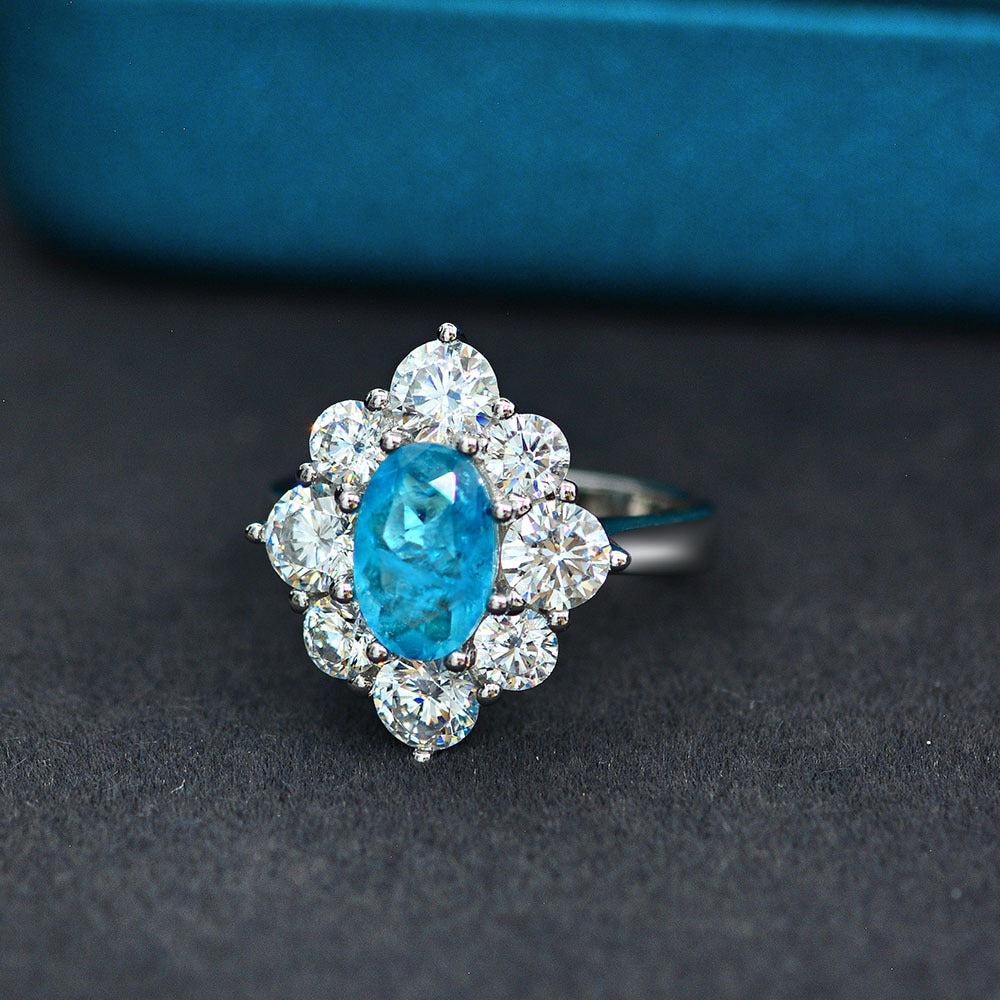 Anillo con zafiro azul Paraíba en forma ovalada, rodeado de circonia cúbica en un halo de plata esterlina 925