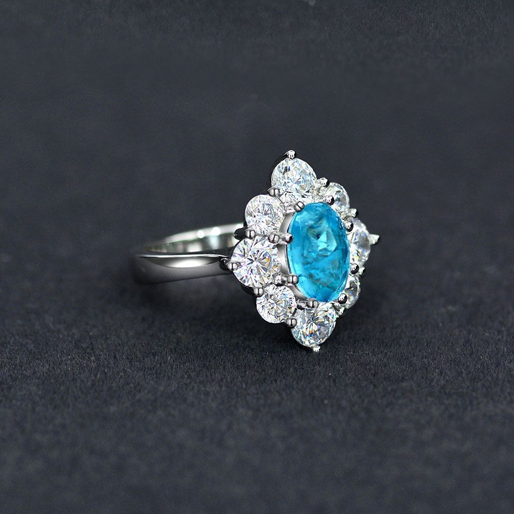 Anillo con zafiro azul Paraíba en forma ovalada, rodeado de circonia cúbica en un halo de plata esterlina 925